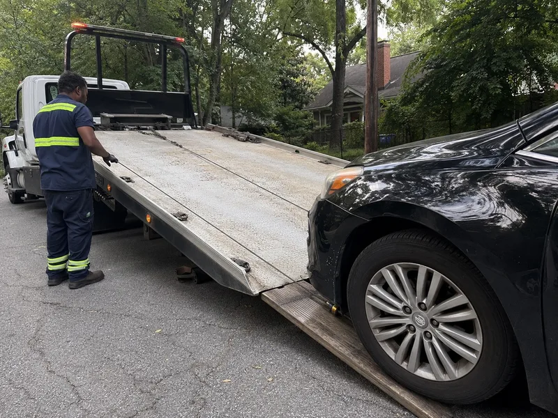 Flatbed tow truck loading a sedan in Atlanta GA