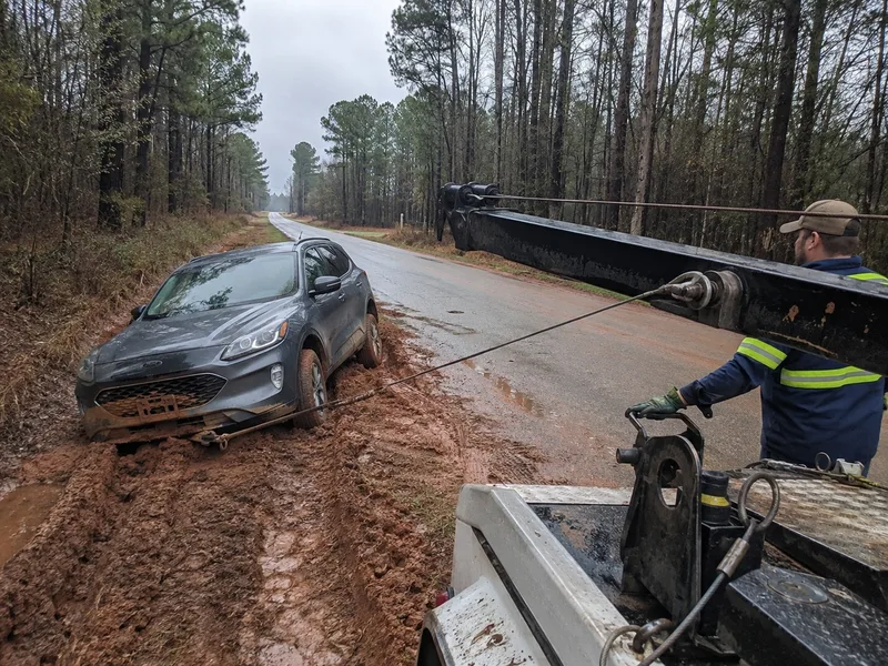 Tow truck winching a car out of a ditch near Atlanta